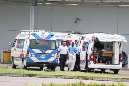 Emergency medical technicians mill around ambulances parked outside the Couva Hospital and Multi-Training Facility after dropping off COVID-19 patients yesterday.