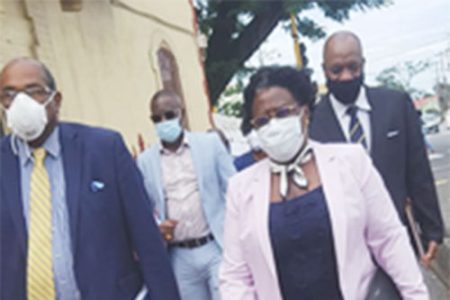 Simona Broomes (at right) and Dexter Austin (second, from left at rear) making their way to the courtroom yesterday morning. Accompanying them were attorney Nigel Hughes ( at left) and former Director General in the Ministry of the Presidency Joseph Harmon. 