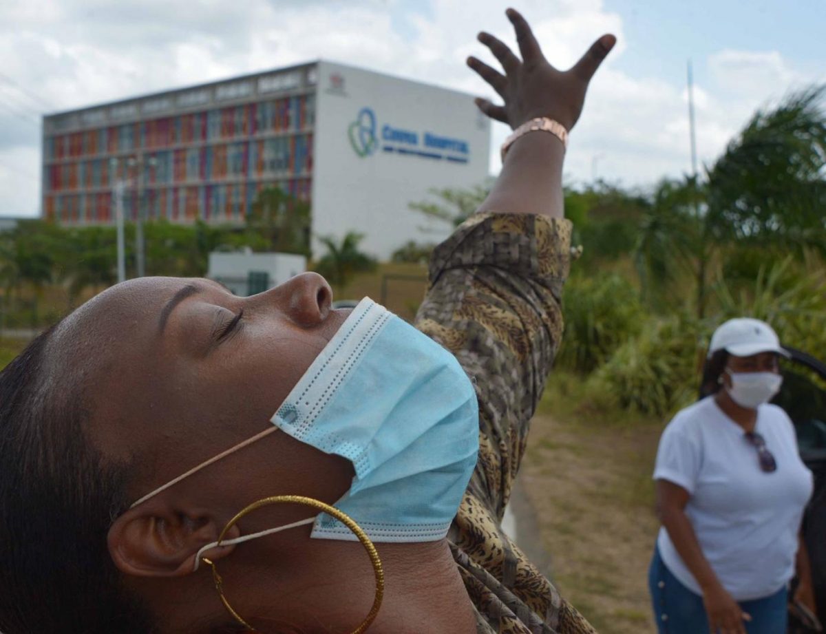 FLASHBACK: Keishel Luces, of Devine Encounter Fellowship Church in Da Badie, says a prayer for COVID-19 victims at the entrance to the Couva Hospital and Multi-Training Facility. -Photo: DEXTER PHILIP 