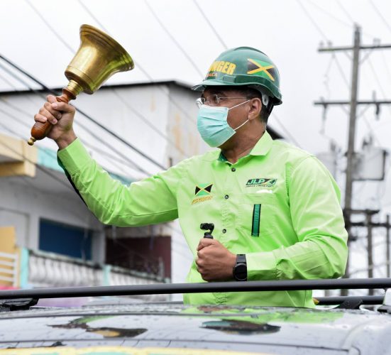 Jamaica Labour Party Leader Andrew Holness rings the bell for supporters who stood in the rain to see him as he toured sections of St Catherine North Central, St Catherine North Western and St Catherine North Eastern on Thursday, August 20.