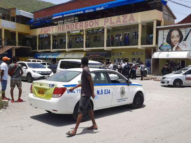 Police investigators at the crime scene. Shortly before 11 a.m today, a Gleaner team in the area heard at least a dozen loud explosions. After receiving several shots inside a bar on the third floor, the barber fell two floors down landing in front of the Spanish Grain meat outlet - Corey Robinson photo