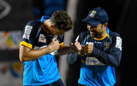 Mitchell Santner (left) and Rashid Khan celebrate the first wicket of Chris Lynn.
