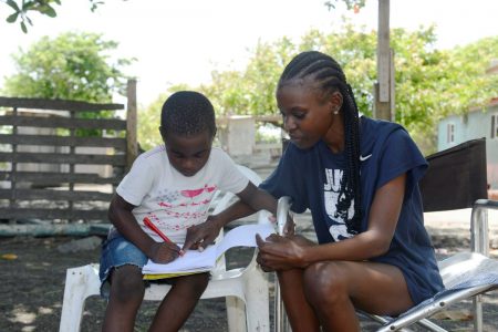 Petergay McKay was seen under a tree, homeschooling her son, Nicquan Miller, in Port Royal on Thursday.