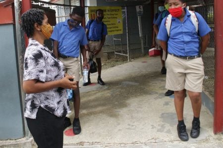 Standard 5 teacher Sharon Jackman chats with her students at the St Paul’s Boys’ Anglican Primary School, San Fernando, yesterday, after classes were dismissed. Prime Minister Dr Keith Rowley yesterday announced Government had decided to scrap the SEA preparation classes due to the COVID-19 spike.