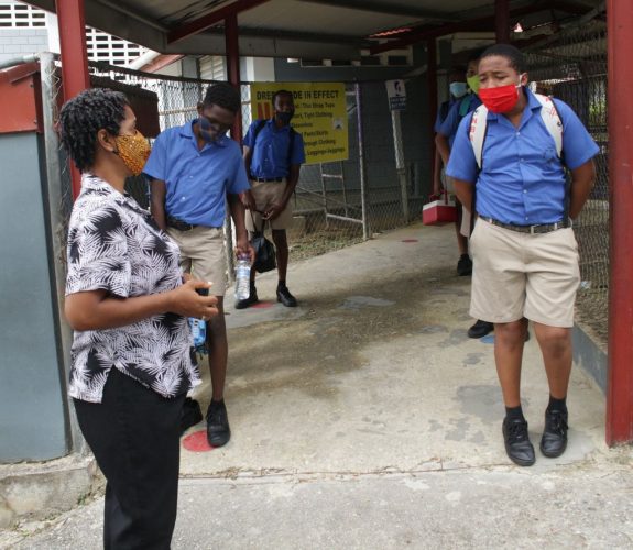 Standard 5 teacher Sharon Jackman chats with her students at the St Paul’s Boys’ Anglican Primary School, San Fernando, yesterday, after classes were dismissed. Prime Minister Dr Keith Rowley yesterday announced Government had decided to scrap the SEA preparation classes due to the COVID-19 spike.