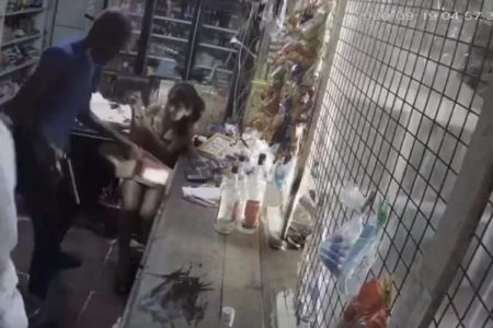A screenshot taken from  the surveillance footage which captured the robbery  showing two of the bandits behind the counter carrying out the attack.
