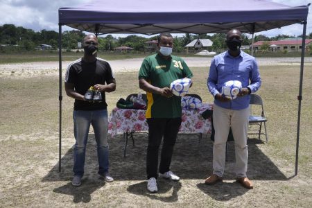 GFF President Wayne Forde (right), Coomacka United FC President Renison Rawlins (center) and UDFA Boss Terrance Mitchell displaying the footballs which were presented from the federation to the club.
