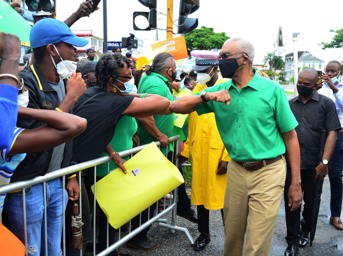Former President David Granger greeting a supporter yesterday outside the High Court (Orlando Charles photo)