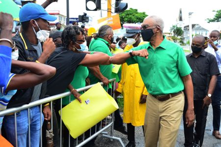 Former President David Granger greeting a supporter yesterday outside the High Court (Orlando Charles photo)