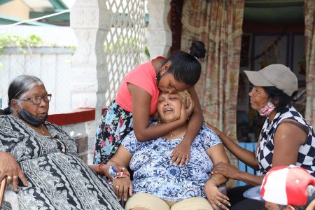 Davica Kanchan, mother of Reshma Kanchan, is consoled by a relative yesterday after hearing her daughter had been killed by her former lover a short distance away from her Laltoo Trace, Debe home yesterday.