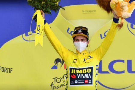 Primoz Roglic of Slovenia wearing the overall leader’s yellow jersey, celebrates on the podium.(Reuters photo)