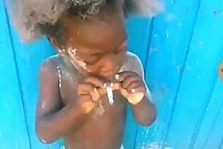 A screenshot from the video of the child with a lit cigarette in his mouth