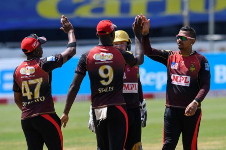 Sunil Narine, right, and Jayden Seales, centre, of Trinbago Knight Riders celebrate the dismissal of Shai Hope of Barbados Tridents during their Caribbean Premier League match at the Brian Lara Cricket Academy in Tarouba, San Fernando on August 23. (Photo by Randy Brooks - CPL T20/Getty Images)