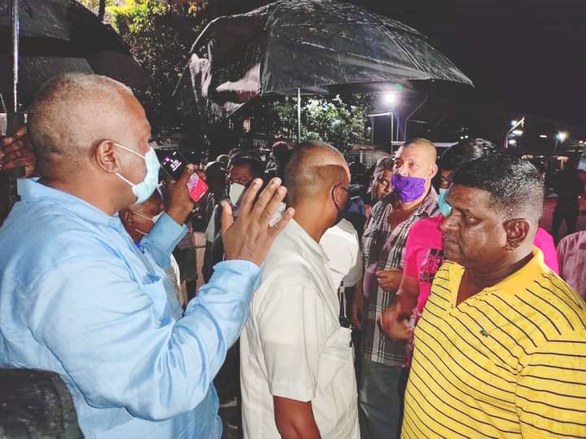 Stranded residents: Prime Minister, Brigadier Mark Phillips (left)  speaking last night with residents of East Berbice-Corentyne who are stranded in the community of Bush Lot, West Coast, Berbice following protests in the area. (From the PM’s Facebook page)