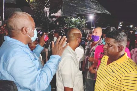 Stranded residents: Prime Minister, Brigadier Mark Phillips (left)  speaking last night with residents of East Berbice-Corentyne who are stranded in the community of Bush Lot, West Coast, Berbice following protests in the area. (From the PM’s Facebook page)