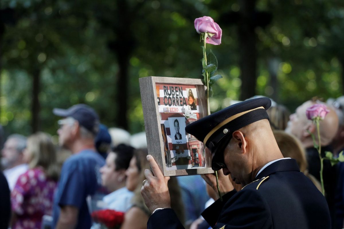 A man holds a photo of a victim during a ceremony marking the 18th anniversary of the 9/11 attacks at the National September 11 Memorial last year in New York.