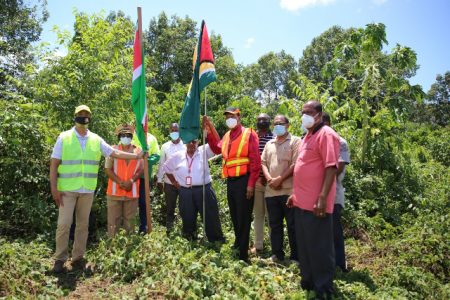 Flag bearers: Minister of Public Works Juan Edghill (at right with flag) and his Surinamese counterpart Dr Riad Nurmohamed planting of flags at Moleson Creek yesterday, during visits to the proposed sites for the landing of a planned bridge across the Corentyne River. (Department of Public Information) 