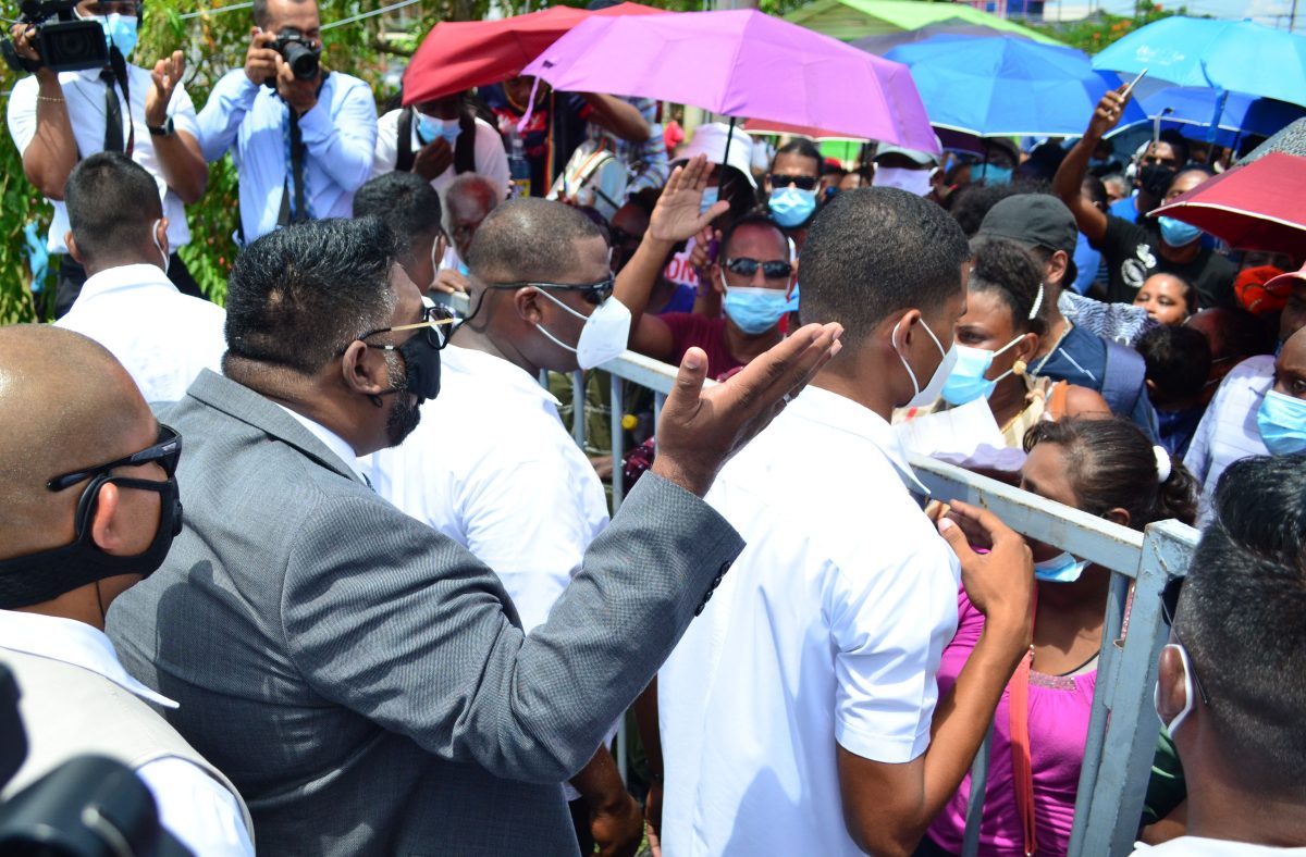 President Irfaan Ali assures the crowd outside of the “Dream Realised” title distribution ceremony that their queries about house lots and applications will be addressed (Photo by Orlando Charles) 