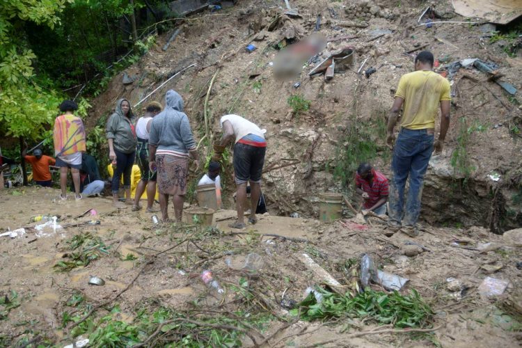 The residents of Shooters Hill in St Andrew working feverishly to dig through debris for a missing 15-year-old student of The Queen’s School whose father’s body was found after a landslide yesterday fell on the house they were in.