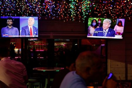 The dual town halls of US Democratic presidential candidate Joe Biden and US President Donald Trump, who are both running in the 2020 U.S. presidential election, are seen on television monitors at Luv Child restaurant in Tampa, Fla., Oct. 15, 2020.
