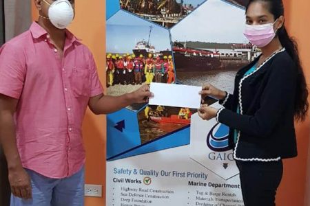 The Guyana Chess Federation’s Anand Raghunauth, left,  receives the sponsorship cheque from GAICO’s Natasha Lakraj. (Photo courtesy of the GCF)