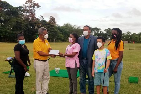 Former President, Samuel Hinds (second from left) presents the cheque to Monette Harry in the presence of GGA President, Aleem Hussain (in suit), Women’s Amateur Division winner, Leota King, Marcus Hinds and Niketa Ashby. 