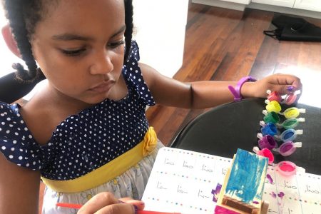 A little girl learns through painting while at home
