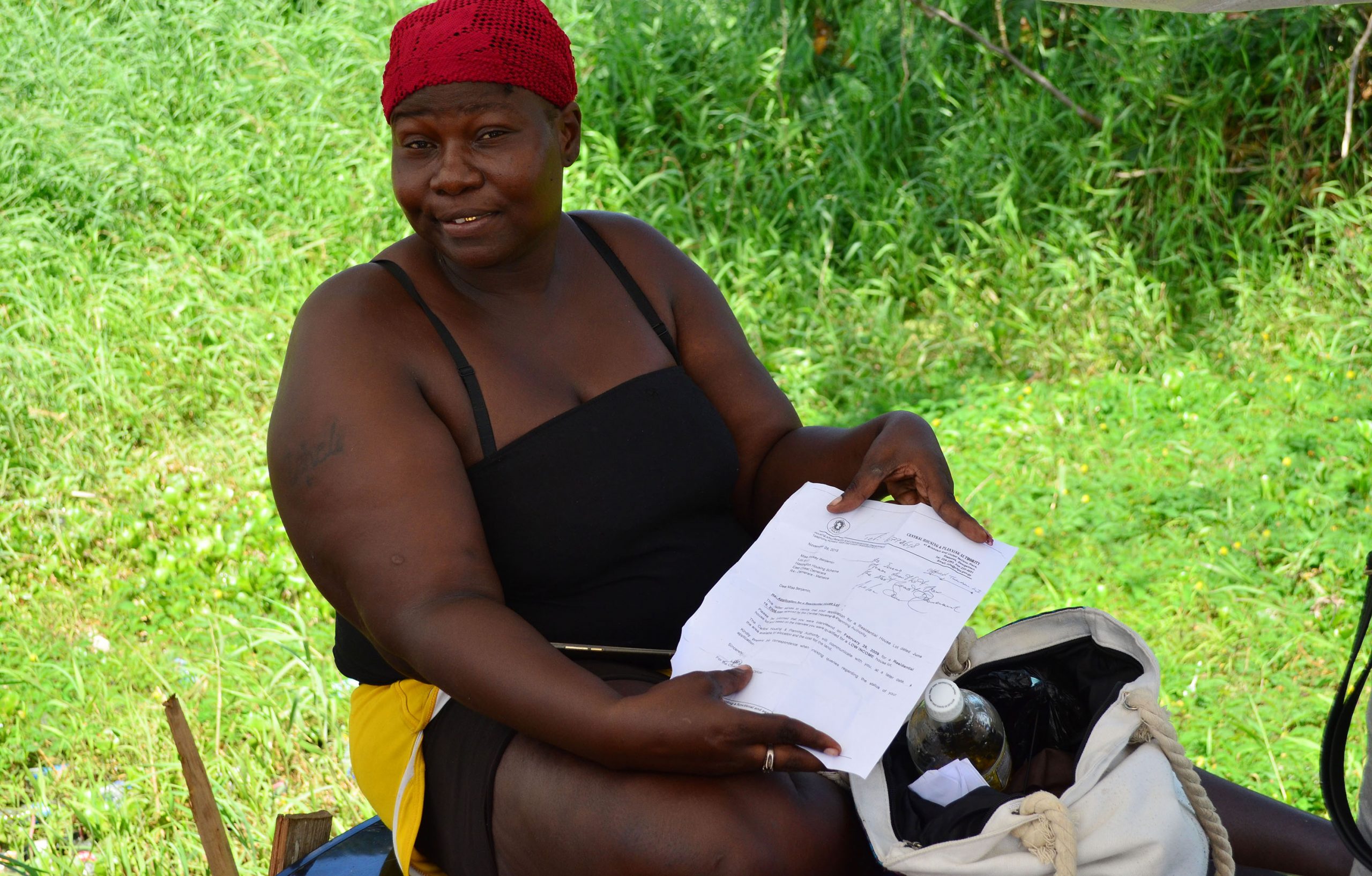 Pinkey Benjamin displaying her letter from the Central Planning and Housing Authority after she applied for a house lot in 2006 (Photo by Orlando Charles)