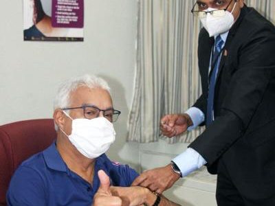 Health Minister Terrence Deyalsingh gives the ‘thumb up’ after being vaccinated against the influenza virus on October 1 by Director of Women’s Health, Dr Adesh Sirjusingh. 