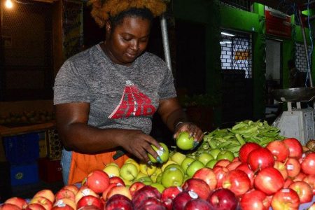 Expected to go up: Vendor Kristy Bullock sells her apples at four for $20 on Independence Square, Port of Spain.