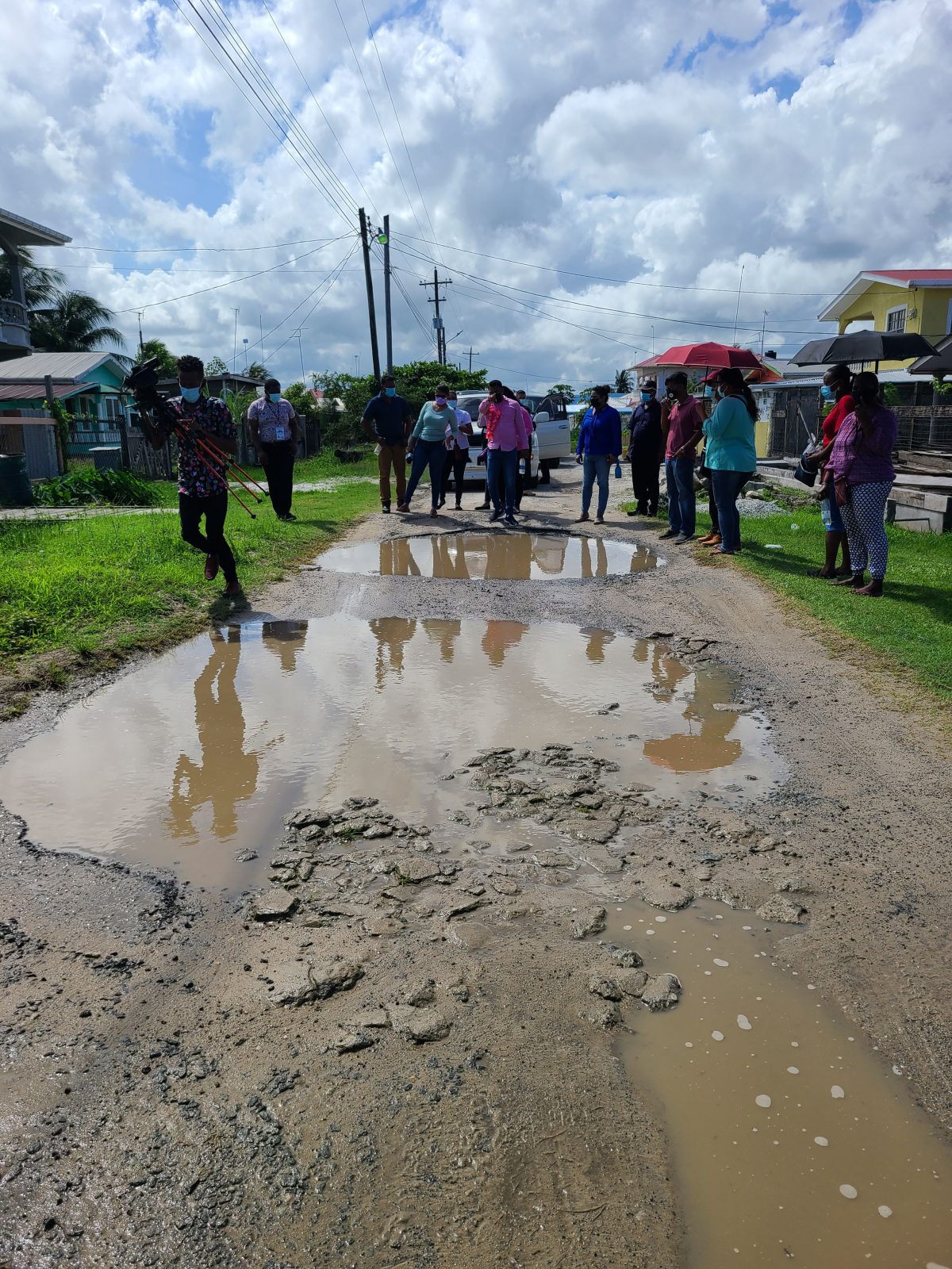 Minister within the Ministry of Public Works Deodat Indar (at centre) examines potholes along one of the Tuschen roads that are due to undergo rehabilitation works soon (Ministry of Public Works photo)

