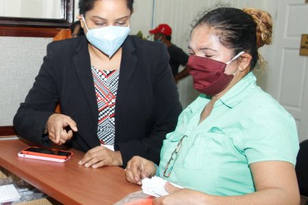 Human Services Minister Dr Vindhya Persaud with one of the persons who delivered masks to the ministry yesterday. (Ministry of Human Services and Social Security photo)