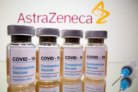Vials with a sticker reading, "COVID-19 / Coronavirus vaccine / Injection only" and a medical syringe are seen in front of a displayed AstraZeneca logo in this illustration taken October 31, 2020. REUTERS/Dado Ruvic