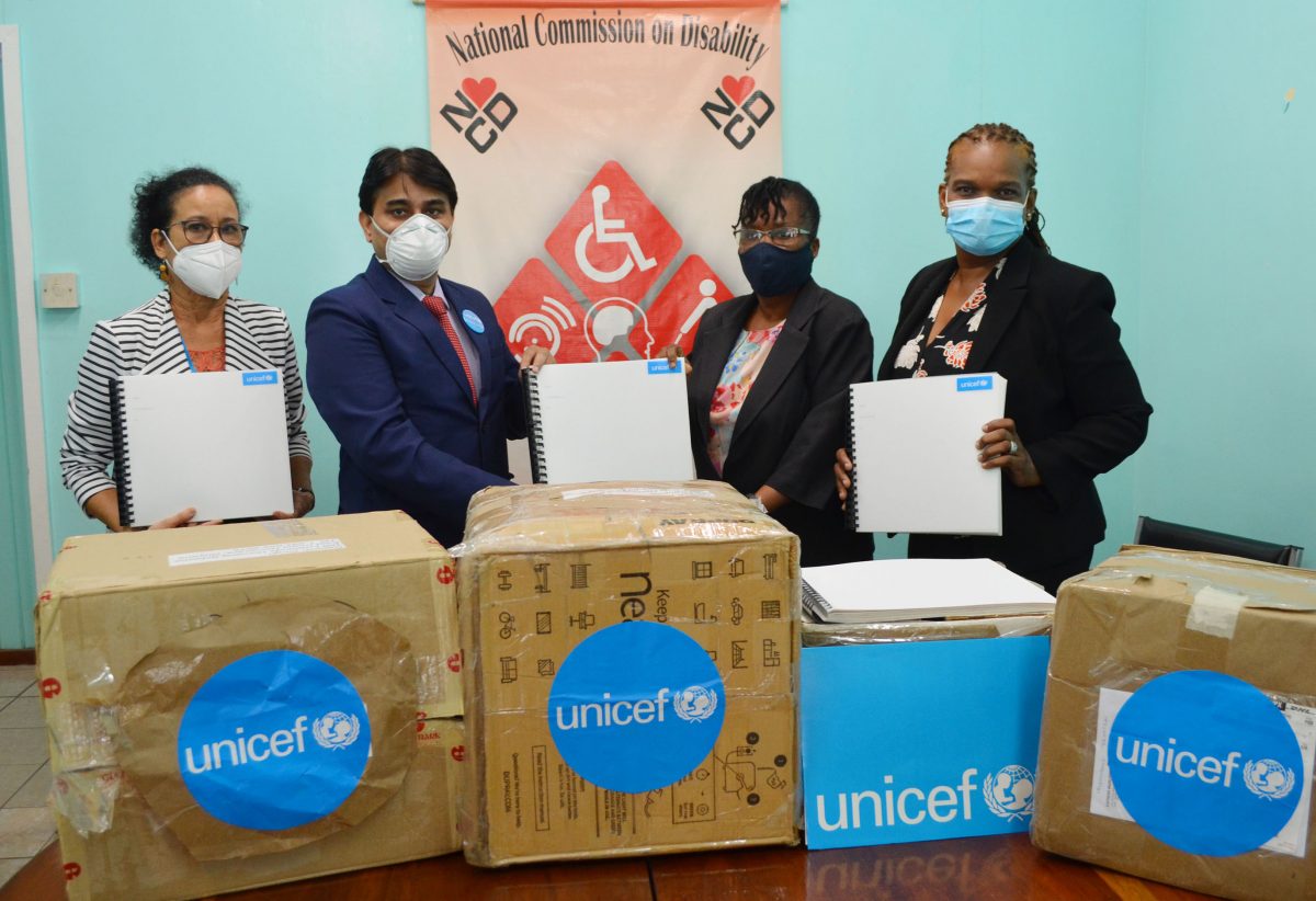UNICEF Representative (acting) Irfan Akhtar (second from left) hands over copies of the Sexual Offences Act reproduced in braille to Executive Secretary of the National Commission on Disability Beverly Pile. Also in photo are UNICEF Education Specialist Audrey Michele Rodrigues (left) and NCD Programme officer Sondra Davidson Low. 
