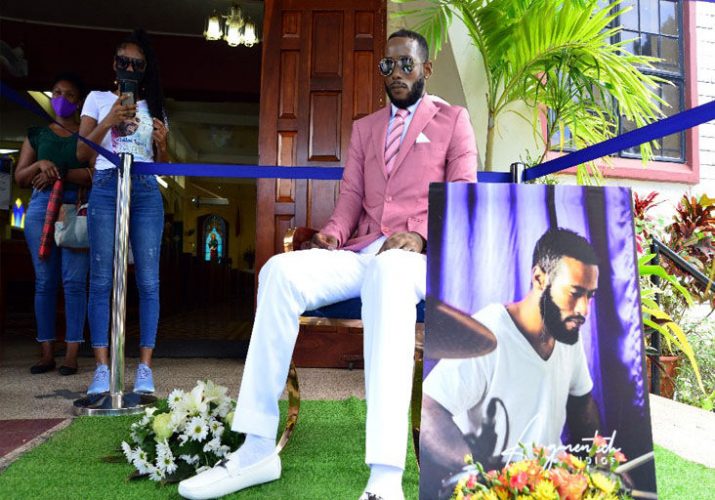 DEAD MAN SITTING: Family and friends view the body of Che Lewis in front of the St John The Evangelist Church, Diego Martin, last Wednesday during the funeral. —Photos: ISHMAEL SALANDY