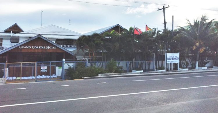 The Grand Coastal Hotel at Le Ressouvenir, East Coast Demerara with a notice informing the public that they are fully booked.