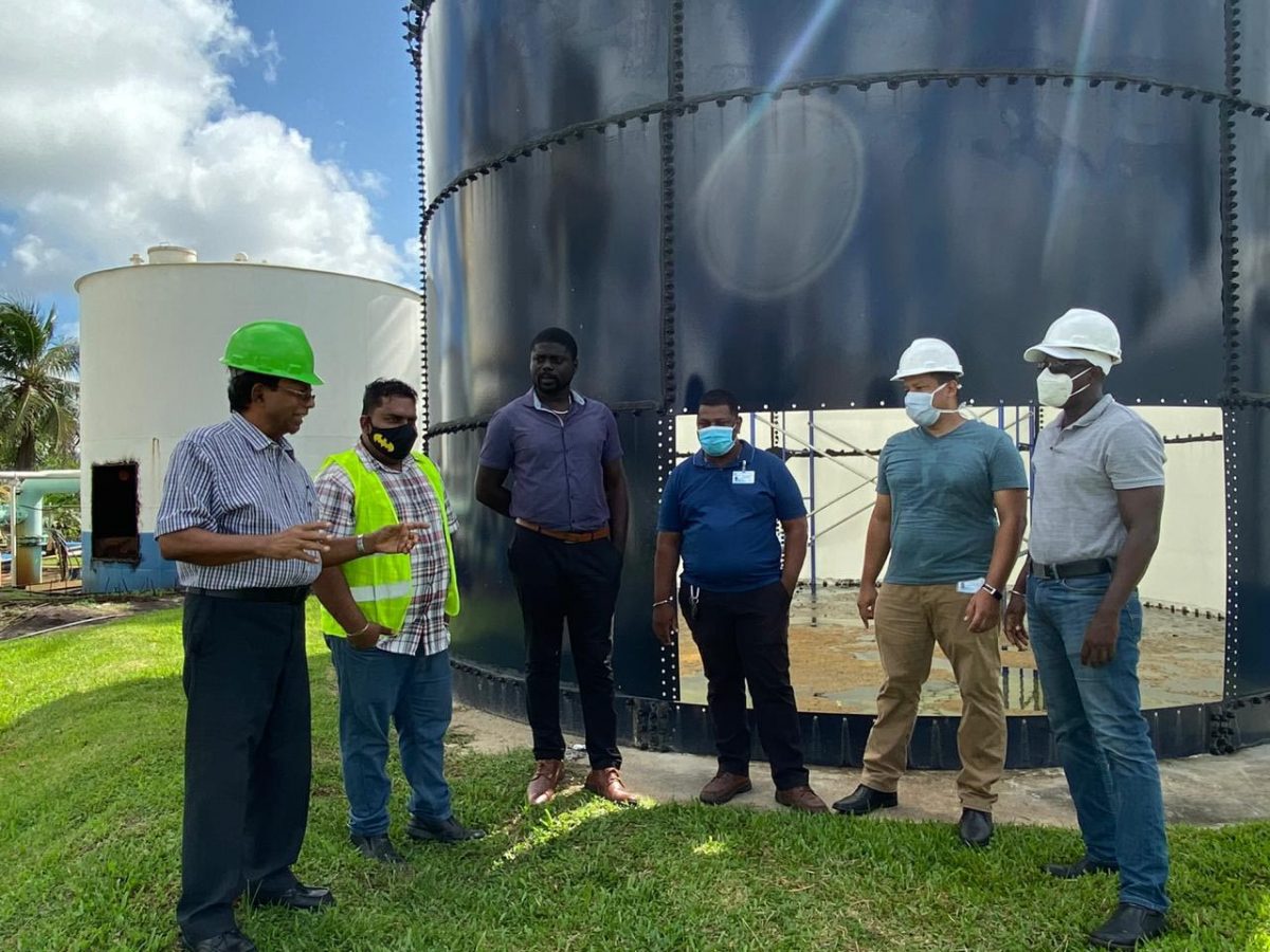 GWI CEO, Shaik Baksh (left) engages a technical team at the Eccles Water Treatment Plant (GWI photo)
