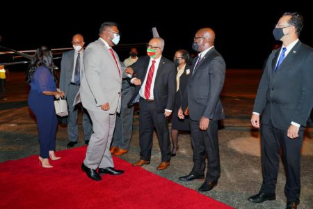 President Irfaan Ali (left) being greeted on his arrival in Suriname last evening by that country’s Foreign Minister Albert Ramdin. First Lady Arya Ali is behind the President. 