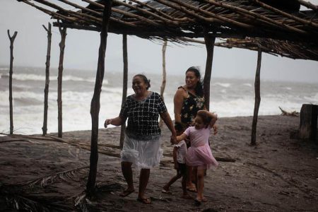 Women react to the wind as Storm Iota approaches, in Cedeno, Honduras November 17, 2020. REUTERS/Jorge Cabrera
