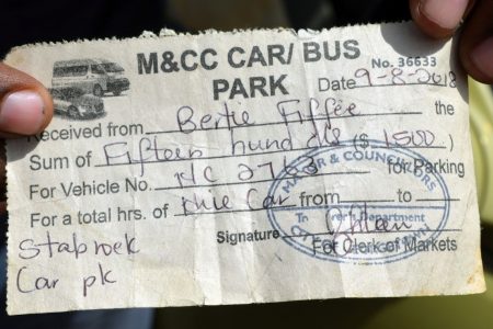 A driver displaying an old receipt for the $1,500 paid to the council (Photo by Orlando Charles)