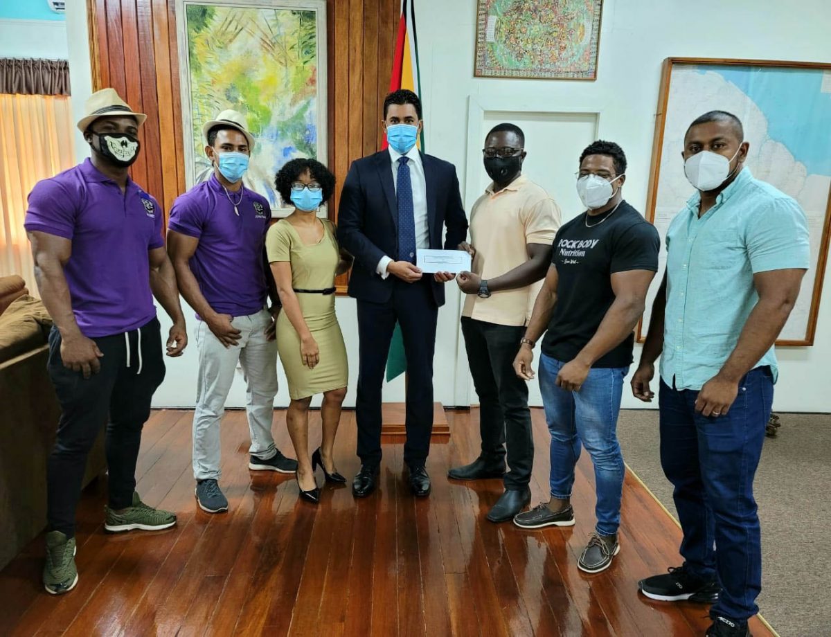 President of the GBBFFI, Keavon Bess (third from right) receives the sponsorship cheque from Sports Minister, Charles Ramson Jr. to help offset expenses for the ‘Resilience’ bodybuilding competition in December. 
