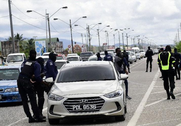 ON PATROL: Police officers question a motorist on the Beetham Highway yesterday during a traffic exercise that also coincided with World Day of Remembrance for Road Traffic Victims which is celebrated on November 15 globally. —Photo: JERMAINE CRUICKSHANK