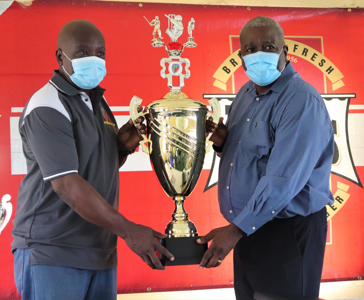 Georgetown Softball Cricket Incorporated President, Ian John (left) and Prime Minister Mark Phillips hold the trophy (Romario Samaroo photo)
