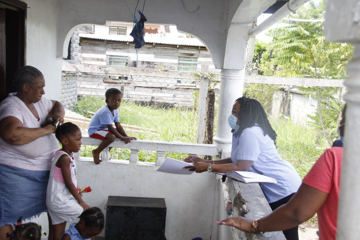 An education officer (right) engaging with a Sophia resident while children look on  (Ministry of Education photo)


