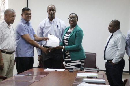 Minister of Education Dr Nicolette Henry (fifth from left) handing over the contract to CEO of BK International Inc, Brian Tiwarie on January 7th this year.
