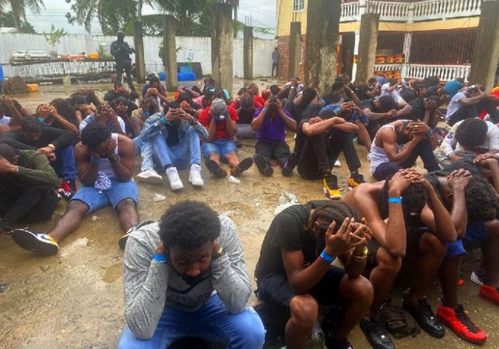 DETAINED: People attending a party at River Branch Trace, off Caroni South Bank Road, are monitored by police after they were detained early yesterday morning.