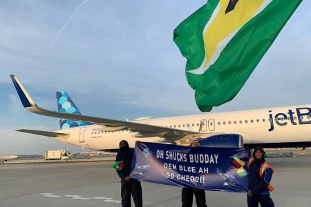 Members of the JetBlue team hold a banner in front of the aircraft used for the airline’s first nonstop flight to Guyana on Friday. (U.S. Embassy Guyana photo)