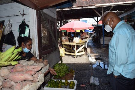 Minister of Public Works, Juan Edghill (right) listens to the complaints of a vendor at the Stabroek Market. (Ministry of Public Works photo)