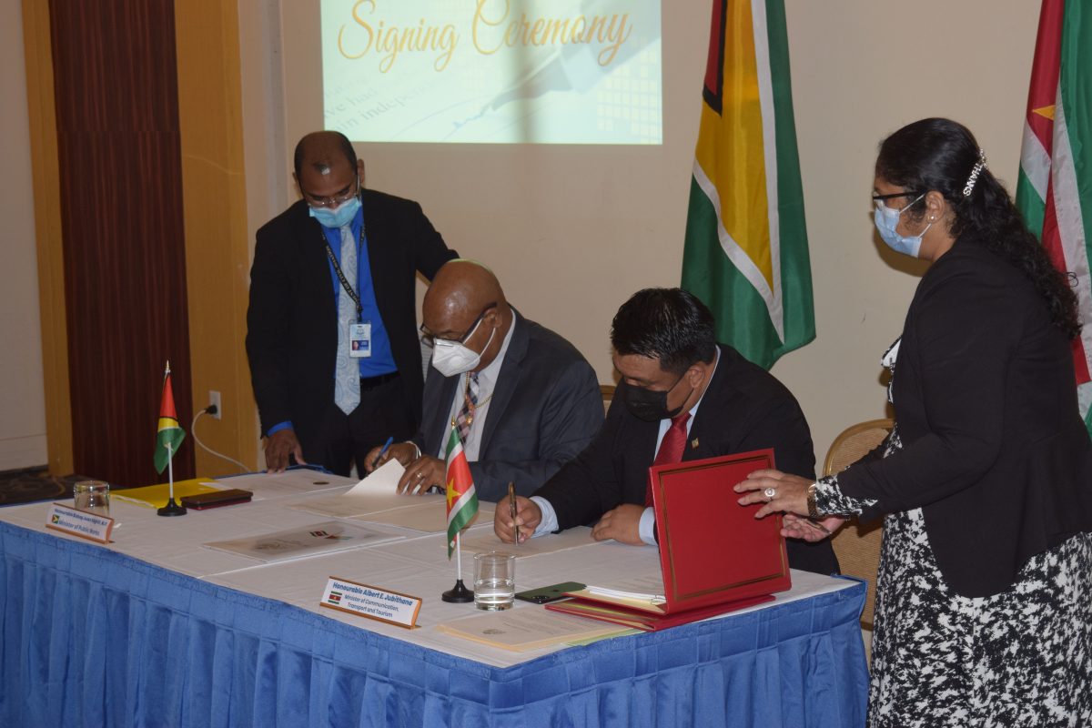 Public Works Minister, Juan Edghill (seated at left) and Suriname’s Transport Minister Albert Jubithana signing the agreement yesterday. (Ministry of Public Works photo)
