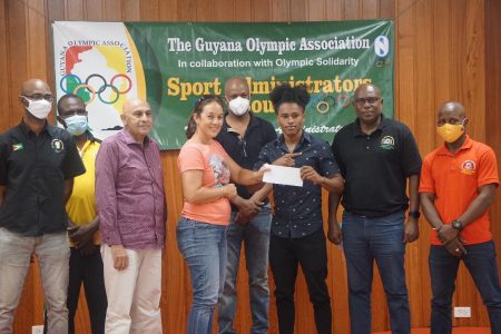 The top brass of the Guyana Olympic Association (GOA) made the scholarship presentation to Keevin Allicock who is ranked 19th in the world in the bantamweight division yesterday at its headquarters at Liliendaal.